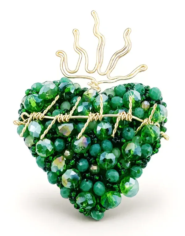 Corazón decorativo tejido con cuentas verdes y borde dorado sobre fondo blanco