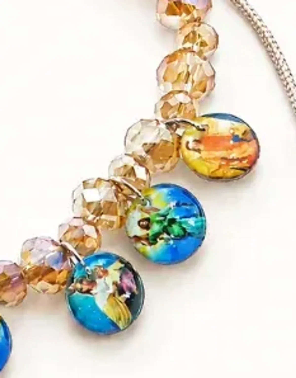 Pulsera artesanal de cuentas color champaña con varias medallas devocionales de colores