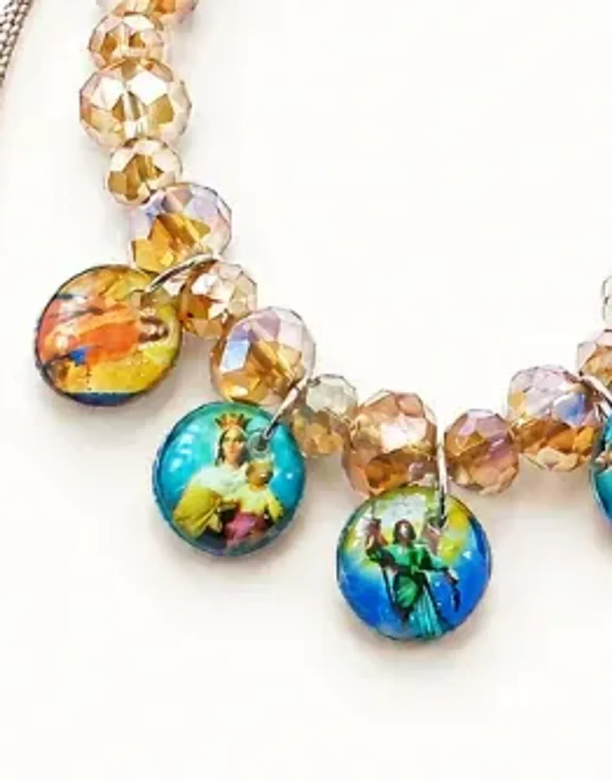 Pulsera artesanal de cuentas color champaña con varias medallas devocionales de colores