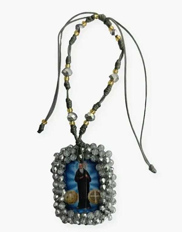 Collar de cuentas negras con detalles dorados y una imagen devocional enmarcada