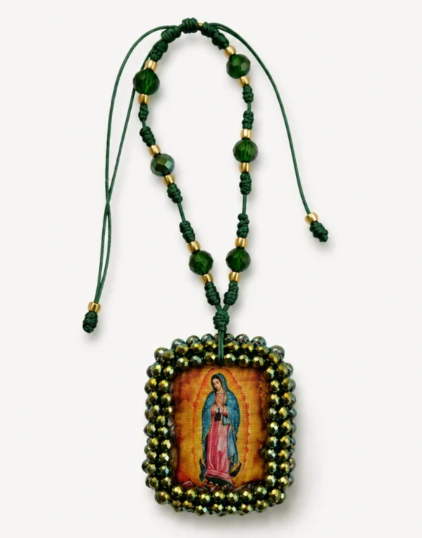 Collar de cuentas en tonos cálidos con una imagen devocional enmarcada sobre una superficie color crema